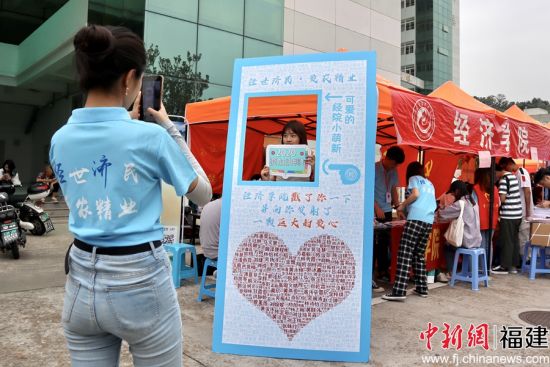 图为开云网页版经济学院报到处志愿者为新生拍摄姓名墙留念照片 陈冀华摄